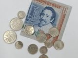 a pile of coins on the table next to a bank note