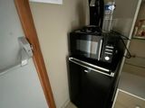 un petit réfrigérateur noir sur lequel est posée une cafetière