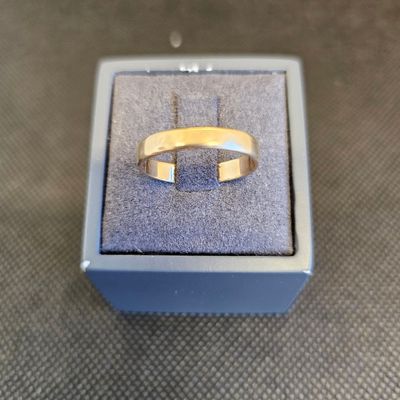 une bague en or posée dans une boîte bleue sur une table