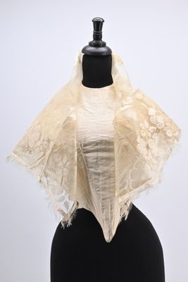 a close up of a mannequin wearing a white shawl on a mannequin