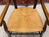 a wooden chair with a woven seat on the floor