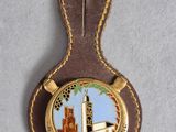 a close up of a badge on a brown leather keychain