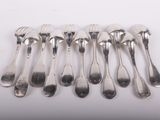 six spoons and a fork are lined up on a white surface