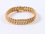 a close up of a gold bracelet on a white background