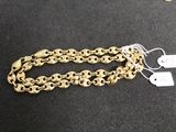 a close up of a gold chain bracelet on a black surface