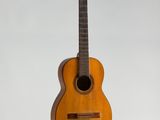 une vieille guitare en bois accrochée au mur