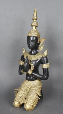 une image représentant une statue noire et dorée posée sur une surface grise