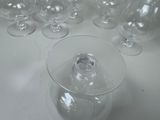 many empty wine glasses on a table with a bottle in the middle