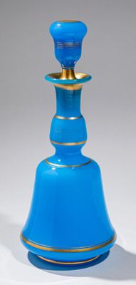 une bouteille en verre bleue ornée d'un liseré doré