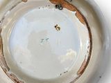 a white bowl with a brown rim on a white surface