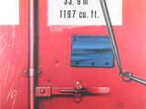 un gros plan sur la porte rouge d'un train, sur laquelle est apposée une pancarte