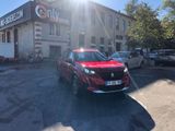 the red car is parked in front of a building in a parking lot