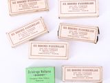 six small wooden business cards are lined up on a white surface