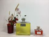 a bottle of perfume next to a vase with flowers in it