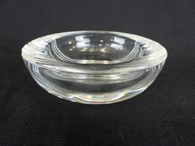 un saladier en verre posé sur une surface noire
