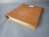 brown leather book with a label on it sitting on top of a table