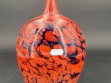 un vase orange et bleu posé sur une table noire