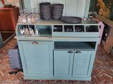 a blue cabinet with a lot of bottles on top of it