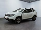 Le SUV Dacia blanc est garé dans une pièce blanche