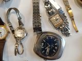 many different types of watches displayed on a table