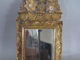 a small mirror with a gold frame on a table