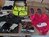 a table with a lot of clothes and shoes on it