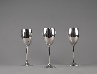 three silver wine glasses sitting next to each other on a table