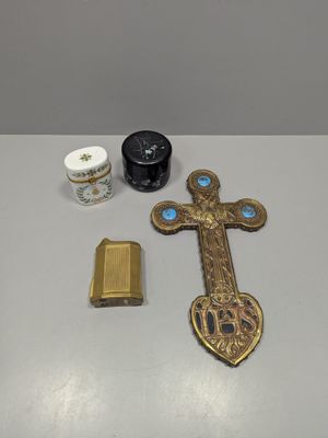 a cross, a lighter, and other items that are on a table