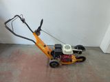a small lawn mower sitting on the floor next to a wall