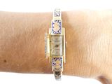 a woman ' s wrist that has a watch on it