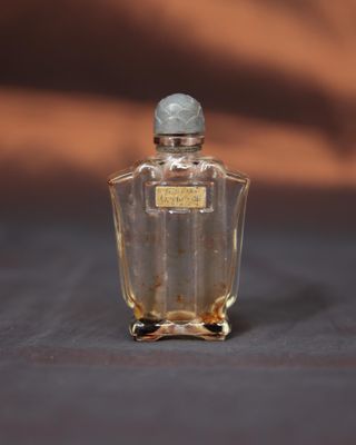 une photo d'un petit flacon de parfum posé sur une table