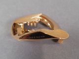 an image of a close up of a gold plated object on a table