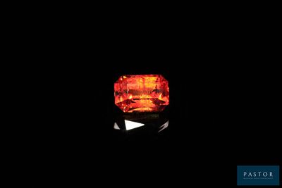gros plan d'un diamant orange sur une surface noire