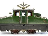 a green train car that is on display on a white surface