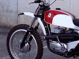 a red and white motorcycle parked in front of a wall
