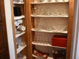 a pantry with a lot of dishes and dishes on the shelves