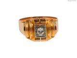 gros plan d'une bague en or avec un diamant au centre
