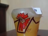 a yellow vase with a red bow on it sitting on a table