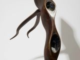 sculpture of a woman standing on one leg with her hands in the air