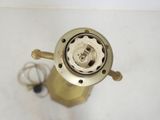 an overhead view of a brass gas burner on a white surface