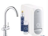 le robinet est à côté du robinet et d'une bouteille d'eau