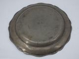 an antique silver plate on a white surface with a white background