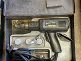 une boîte contenant une perceuse et d'autres outils