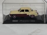 an old model car in a clear case on a white surface