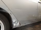 a silver car that is being repaired in the garage
