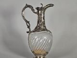 un vase ancien en verre plaqué argent, muni d'une anse, sur fond blanc