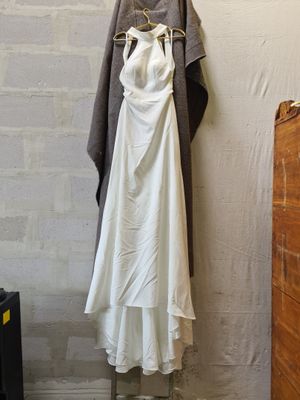 a white dress hanging on a clothes rack in a room