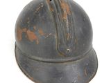 an old helmet with rust on it on a white surface