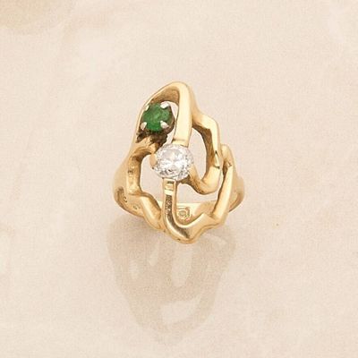a gold ring with a diamond and a green stone