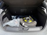 a tire in the trunk of a car with a tire wheel in it
